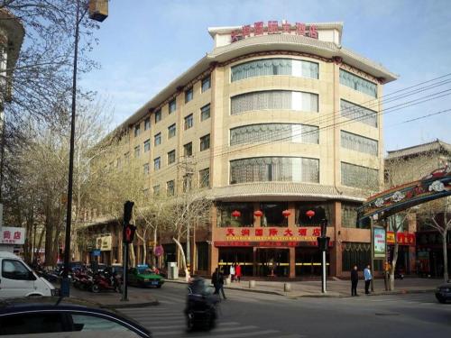 a large building on the corner of a city street at Tianrun International Hotel in Dunhuang