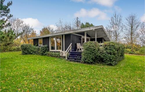 a small black house on a green lawn at Beautiful Home In Rudkøbing With Wifi in Spodsbjerg