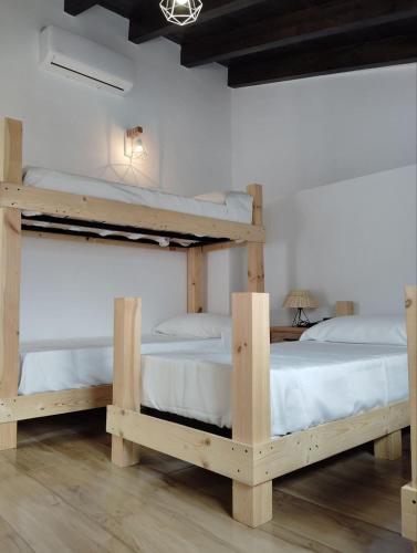 two bunk beds in a room with white sheets at La BUHARDILLA DE CHARLIN in Casas de Ves