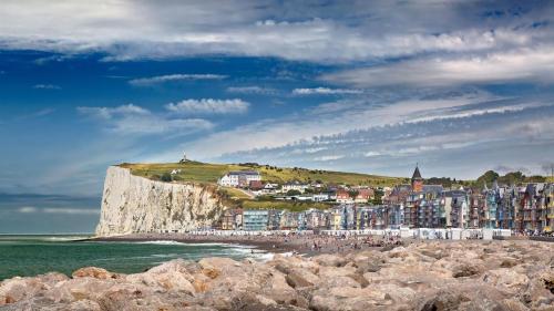 a group of buildings on a cliff next to the ocean at La Ferme du Parc in Pendé