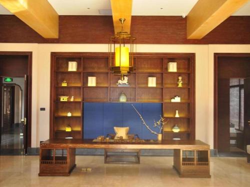 a large table in a room with a wall of shelves at Xian Huaqingyutang Hotel in Xi'an