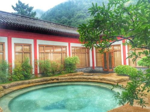 a house with a swimming pool in front of it at Xian Huaqingyutang Hotel in Xi'an