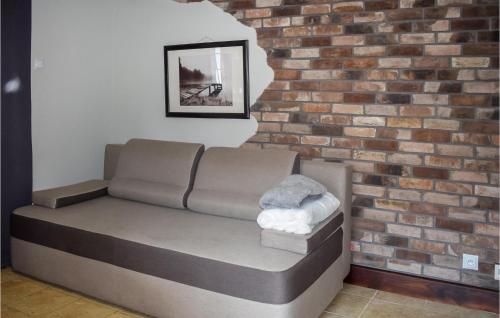 a couch in front of a brick wall at Gorgeous Apartment In Rydzewo in Rydzewo
