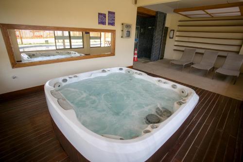 uma banheira de hidromassagem com pedras num quarto em Beach Place Resort Bangalo 12 em Aquiraz