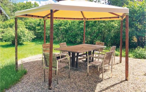 a wooden table and chairs under a gazebo at 4 Bedroom Gorgeous Home In Lindesberg in Lindesberg