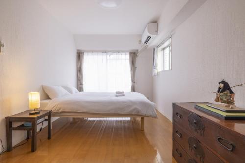 a bedroom with a bed and a dresser and a window at Komorebi in Tokyo