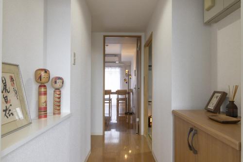 a hallway with white walls and a room with a table at Komorebi in Tokyo