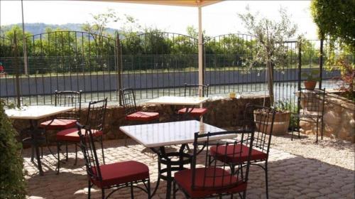 a patio with tables and red chairs and a white table at Relais San Michele in Rivoli Veronese