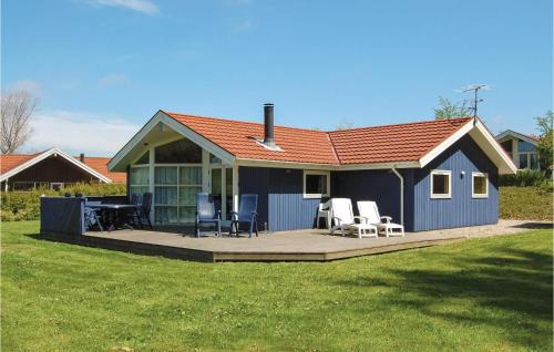 a blue house with a deck and chairs on it at Holiday Home Udsigten Rudkøbing in Spodsbjerg