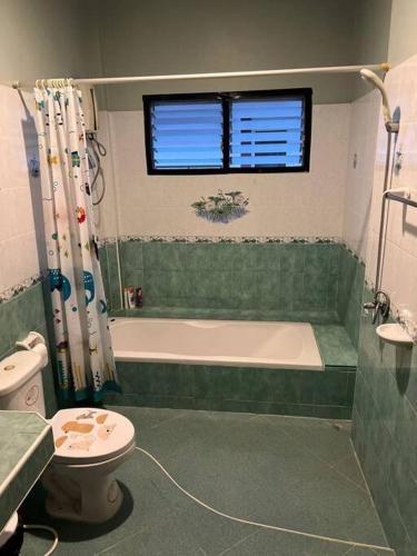 a bathroom with a tub and a toilet and a sink at Dreamcatcher Bungalow in Bophut