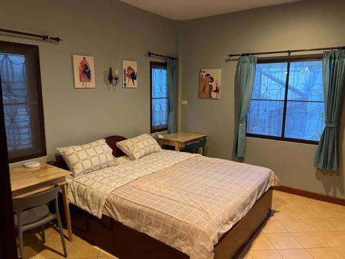 a bedroom with a bed and a desk and windows at Dreamcatcher Bungalow in Bophut