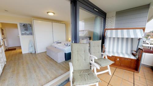 a room with a balcony with a bed and a couch at Haus Calma App 7 in Wenningstedt