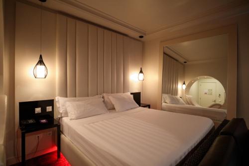a bedroom with a large white bed and a mirror at Habana Motel in Matosinhos