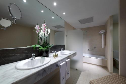 a bathroom with two sinks and a large mirror at Eurostars Zaragoza in Zaragoza