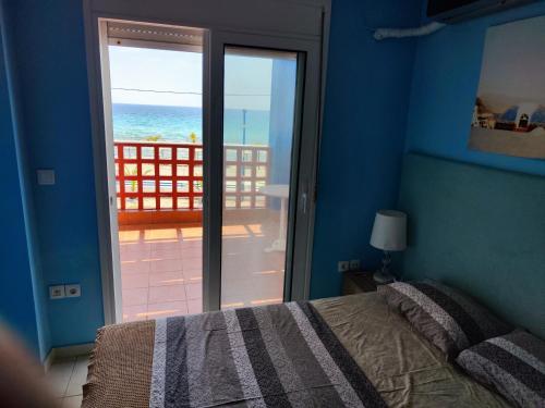 a bedroom with a bed and a view of the ocean at Seaside house in Sozopoli