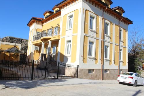 a yellow house with a white car parked in front of it at Villa Paris in Hisarya