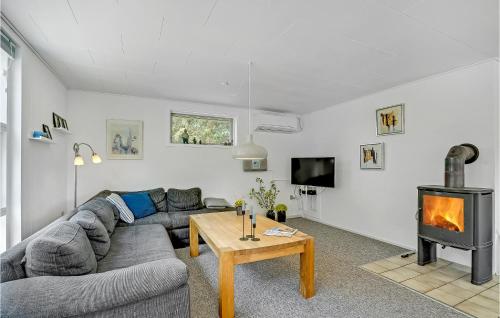 a living room with a couch and a fireplace at Holiday Home Bjergbovej Blåvand Xi in Blåvand