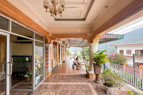 a building with a porch with a chandelier at Hotel Harapan Isyes Syariah RedPartner in Parapat