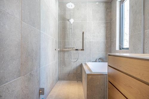 a bathroom with a shower and a sink at Hiiragi by H2 Life in Niseko