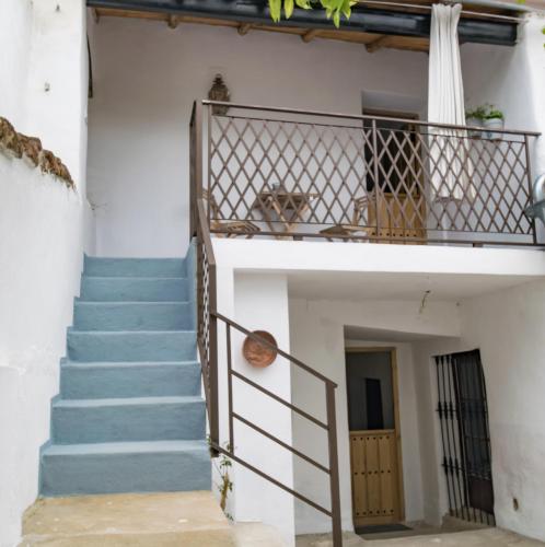 a staircase leading up to a house with a dog on the balcony at Casimiro Alojamiento Rural in Guadalupe