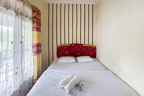 a small bedroom with a bed with towels on it at Hotel Harapan Isyes Syariah RedPartner in Parapat