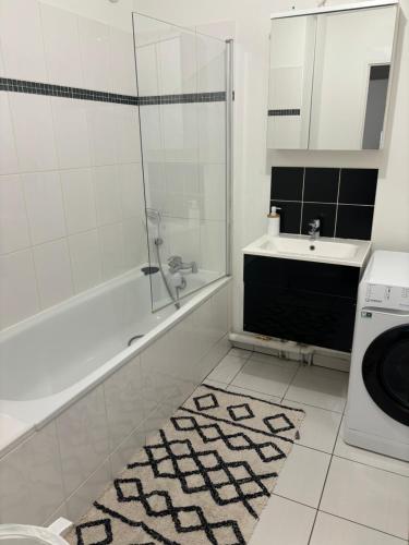 Un baño con lavabo y lavadora. en ORCHIDÉES CHOISY 5Pers Parking Wifi, en Choisy-le-Roi