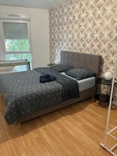 Un dormitorio con una cama y suelo de madera. en ORCHIDÉES CHOISY 5Pers Parking Wifi, en Choisy-le-Roi