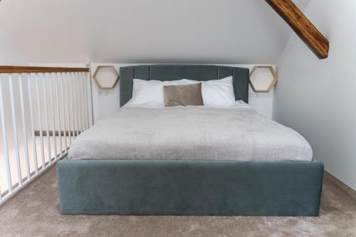 a bed with a blue ottoman in a room at Poema in Oradea