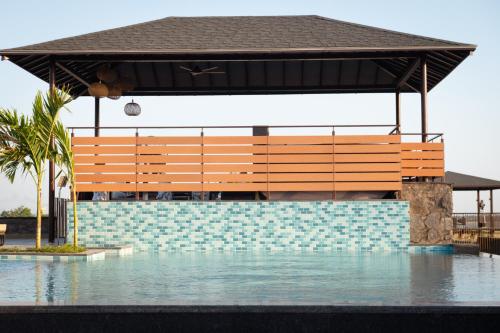 a pavilion over a swimming pool with water in front at Sangam Farms in Bhilwara