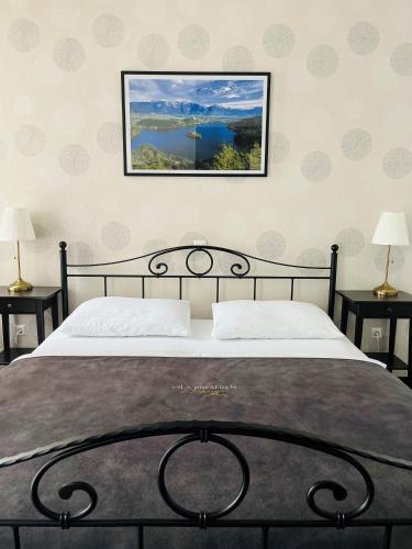 a bedroom with a bed and two tables with lamps at Penzion Vila Prešeren in Bled