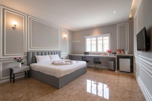 a bedroom with a large bed and a desk at Grandbangsaray in Na Jomtien