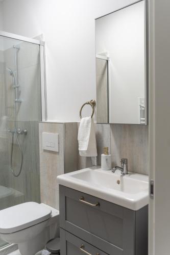 a bathroom with a sink and a toilet and a mirror at Poema in Oradea