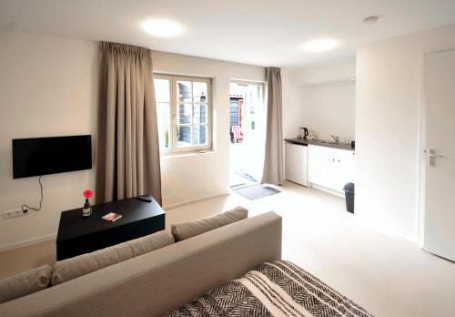 a living room with a couch and a tv at Herberg de Zwaan Hedel in Hedel