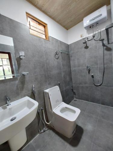 a bathroom with a toilet and a sink at Lake Wave Hotel in Anuradhapura