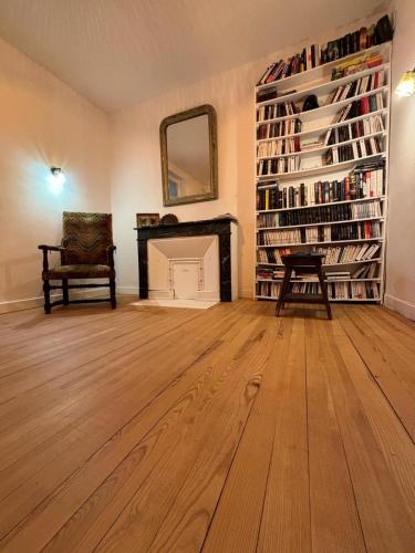 Cette chambre comprend une cheminée, une chaise et un miroir. dans l'établissement l'étape DECAZEVILLE, à Decazeville