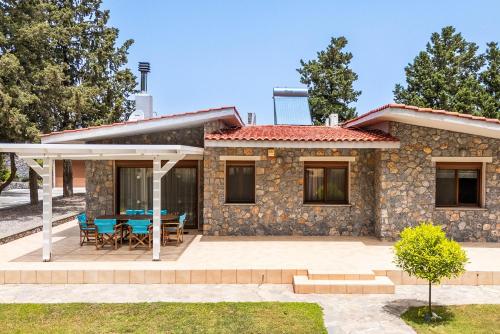 a stone house with a table and chairs at Madia Villa in Kolimbia