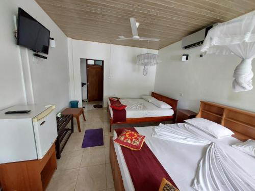 a hotel room with two beds and a tv at Lake Wave Hotel in Anuradhapura