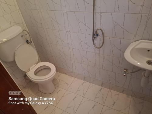 a bathroom with a toilet and a sink at Kal Accommodation in Mbarara