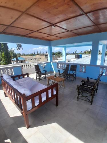 a bedroom with a bed and chairs on a balcony at Kelly Homes in Kilifi