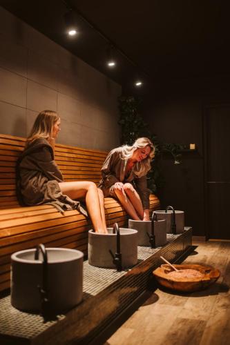 two women sitting on a bench in a room at Best Western Plus Hus 57 in Ängelholm