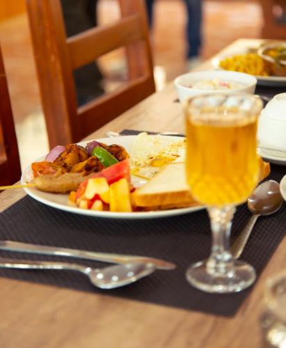 a table with a plate of food and a glass of beer at Hotel Gyan Gauri Palace in Beni
