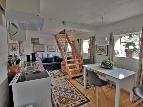 a kitchen and living room with a spiral staircase at Landhaus Westerweg - Familie Petersen in Wanderup