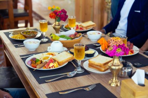a table topped with plates of food and drinks at Hotel Gyan Gauri Palace in Beni