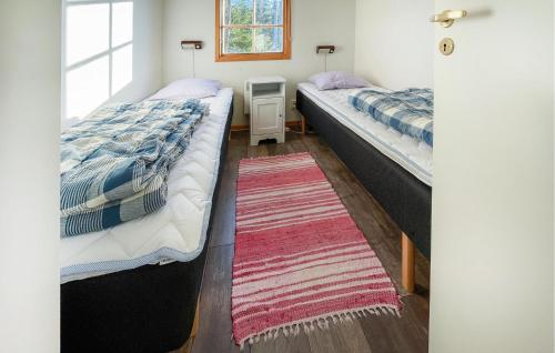 two beds in a small room with a rug at Gorgeous Home In Gislaved With Wifi in Våthult