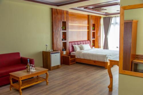 a bedroom with a bed and a red couch at Hotel Gyan Gauri Palace in Beni