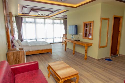 a living room with a bed and a couch at Hotel Gyan Gauri Palace in Beni