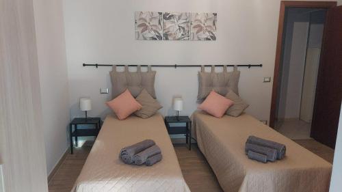 two beds with pillows on them in a room at Appartamento centrale in Lido di Ostia