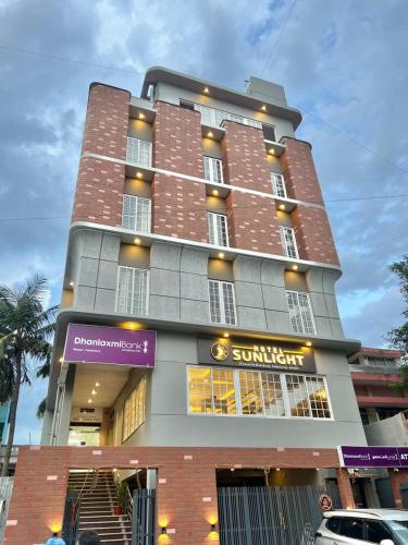 a tall building with a purple sign on it at Hotel Sunlight in Puducherry