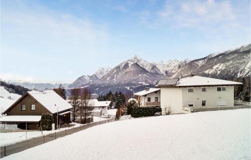a snow covered hill with houses and mountains in the background at Ferienwohnung - Hochgallzein in Gallzein