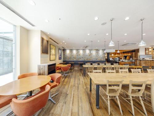 a dining room with wooden tables and chairs at Richmond Hotel Nagoya Nayabashi in Nagoya